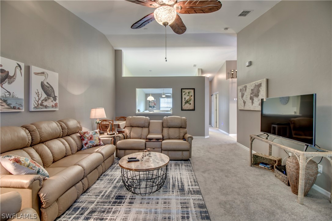 a living room with furniture a ceiling fan and a flat screen tv