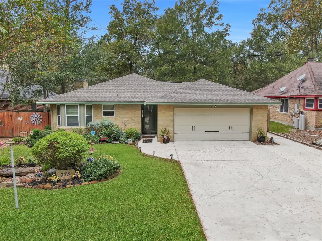 a front view of a house with a yard and trees