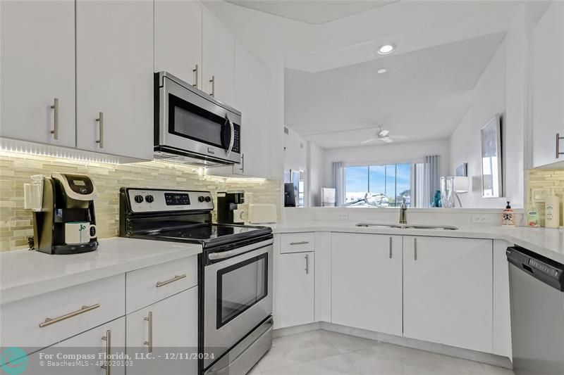 a kitchen with white cabinets and appliances