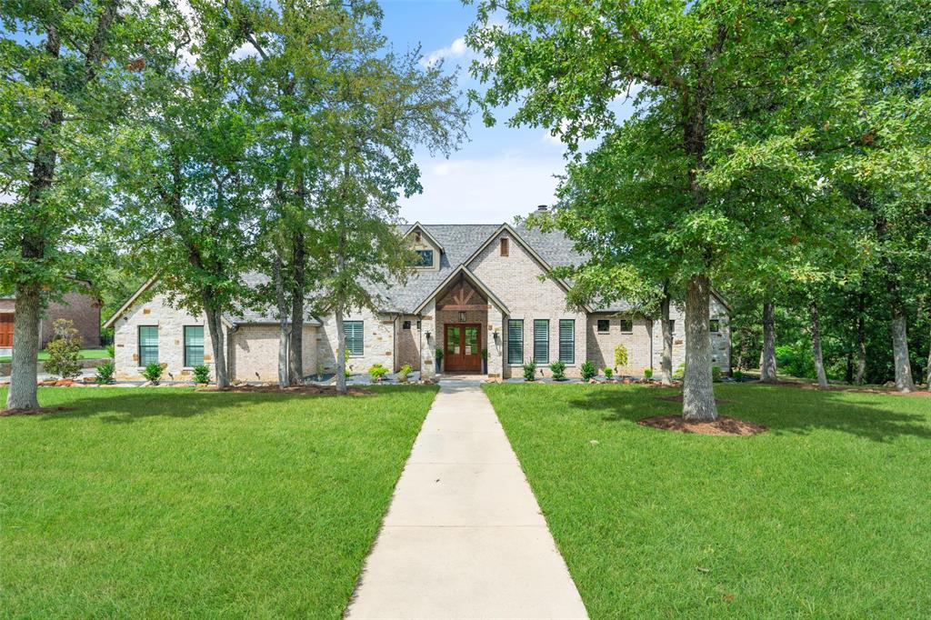 a front view of a house with a yard and trees