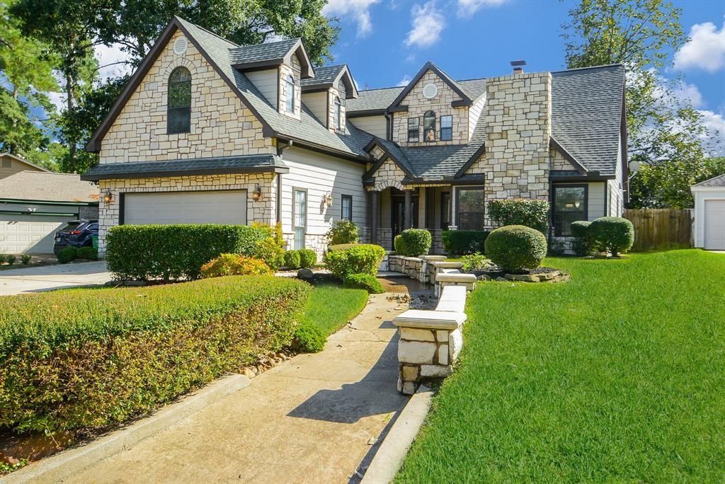 a view of a house with a big yard plants and large tree