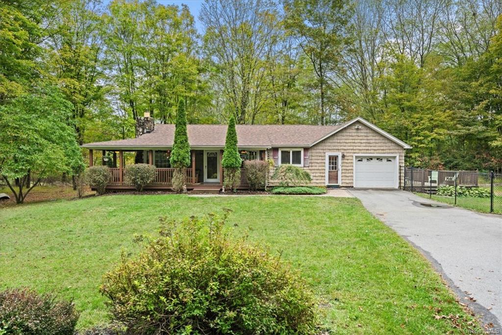 a front view of a house with a yard and trees