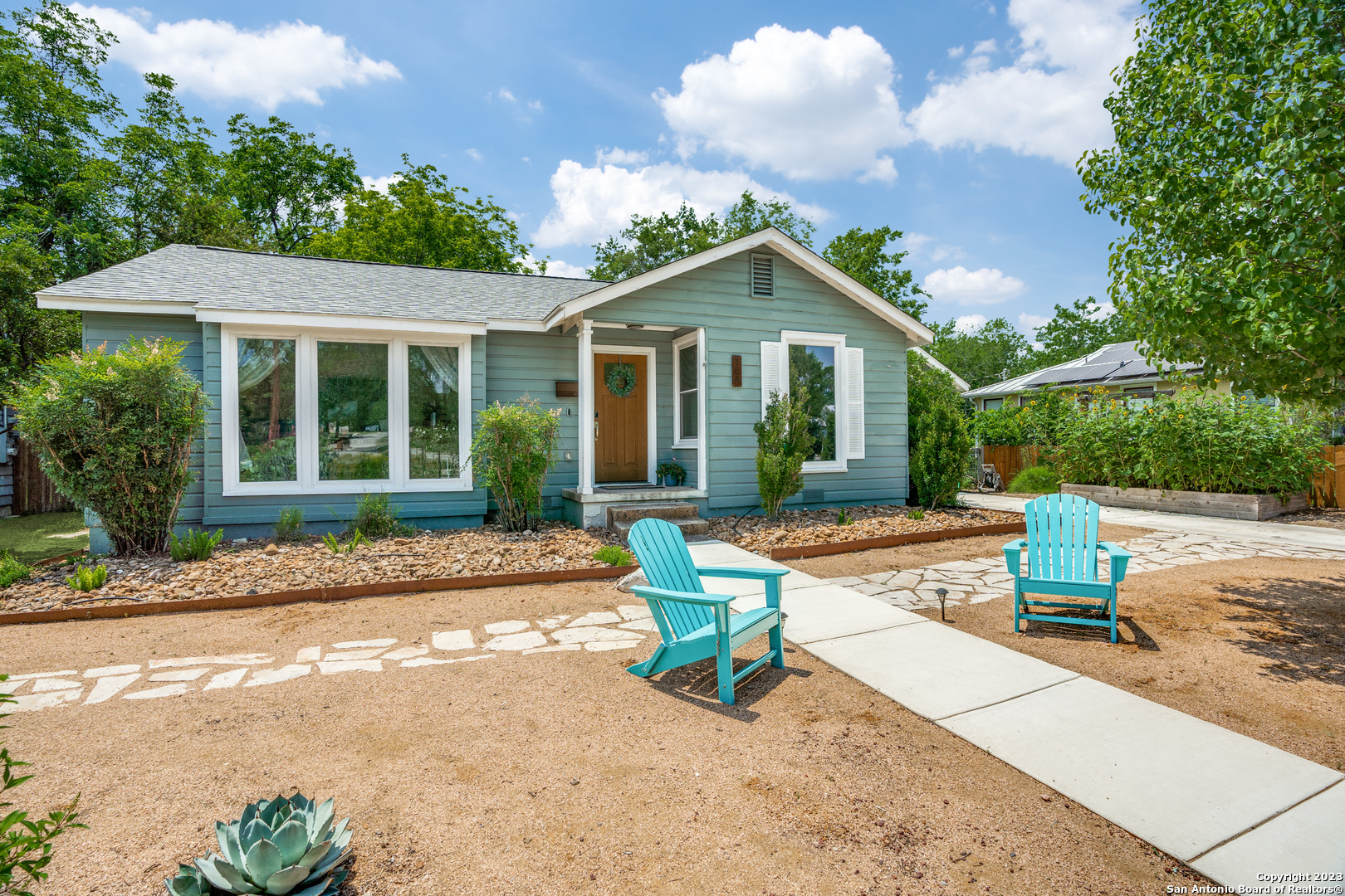 a view of a house with backyard and sitting area