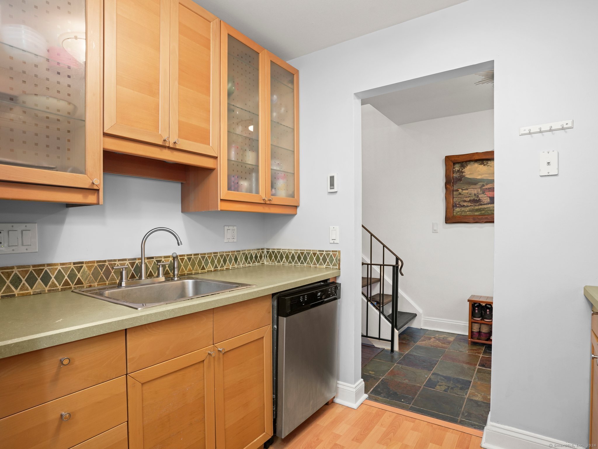 a kitchen with stainless steel appliances granite countertop a sink and cabinets with wooden floor