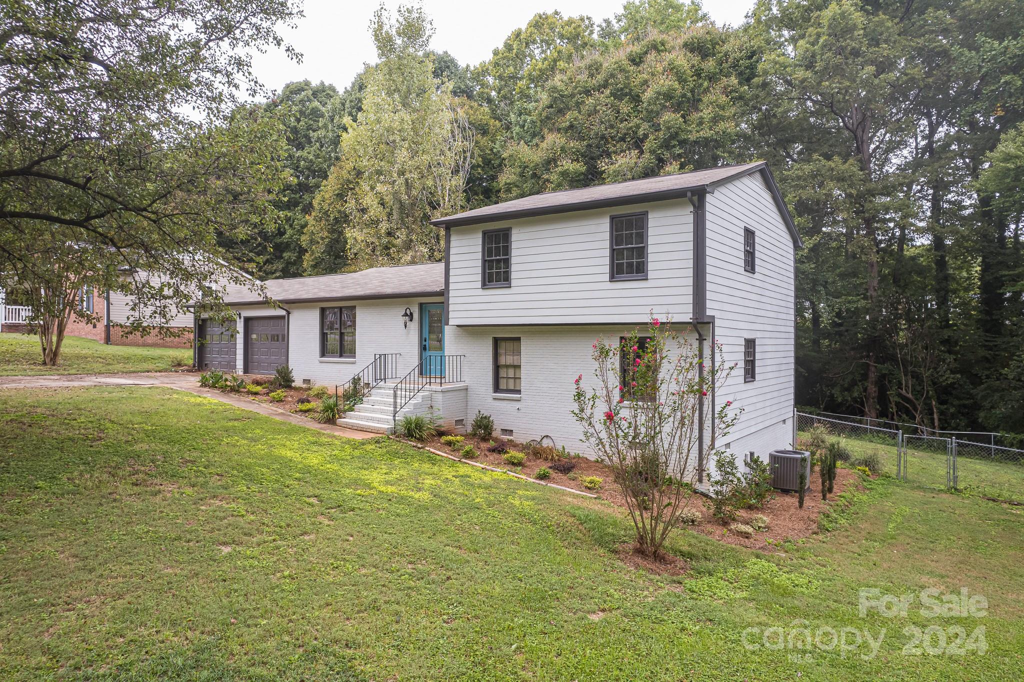 a front view of house with yard and trees in the background