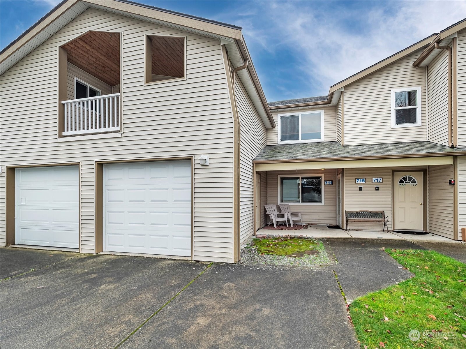 a front view of a house with yard and parking