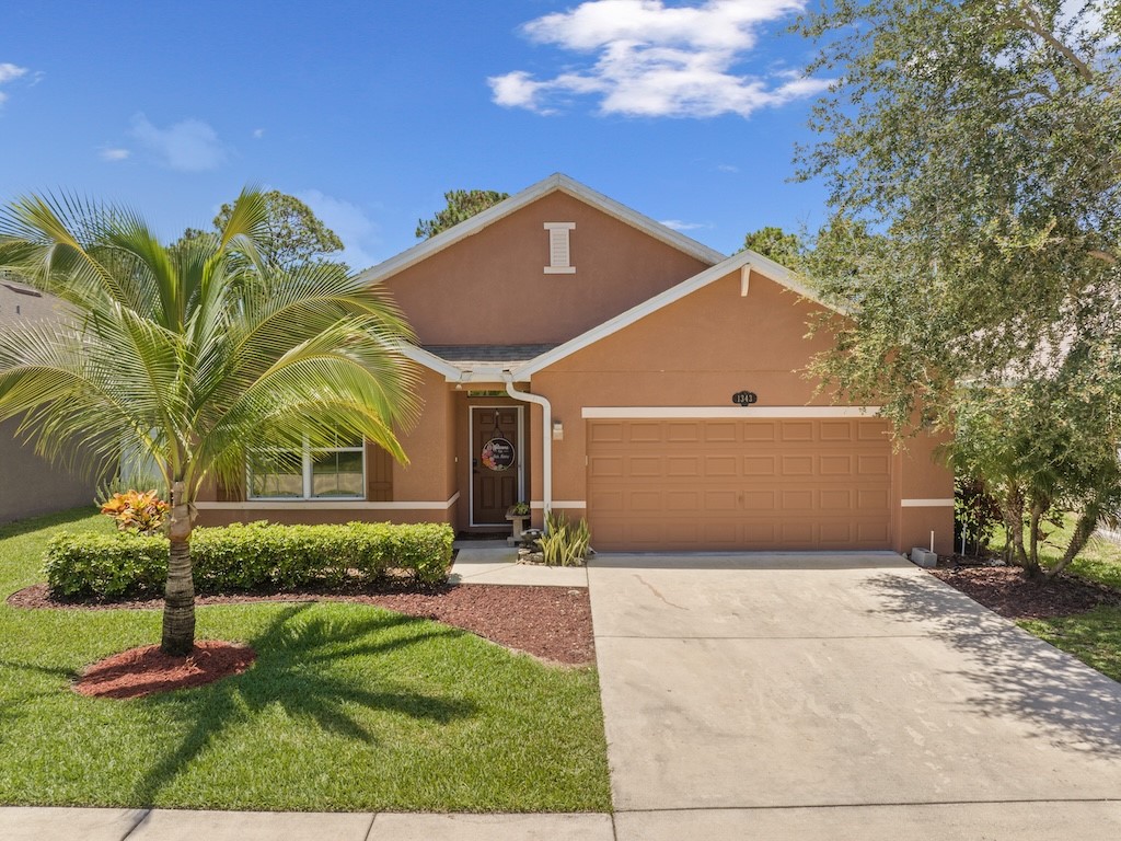 a front view of a house with a yard and garage