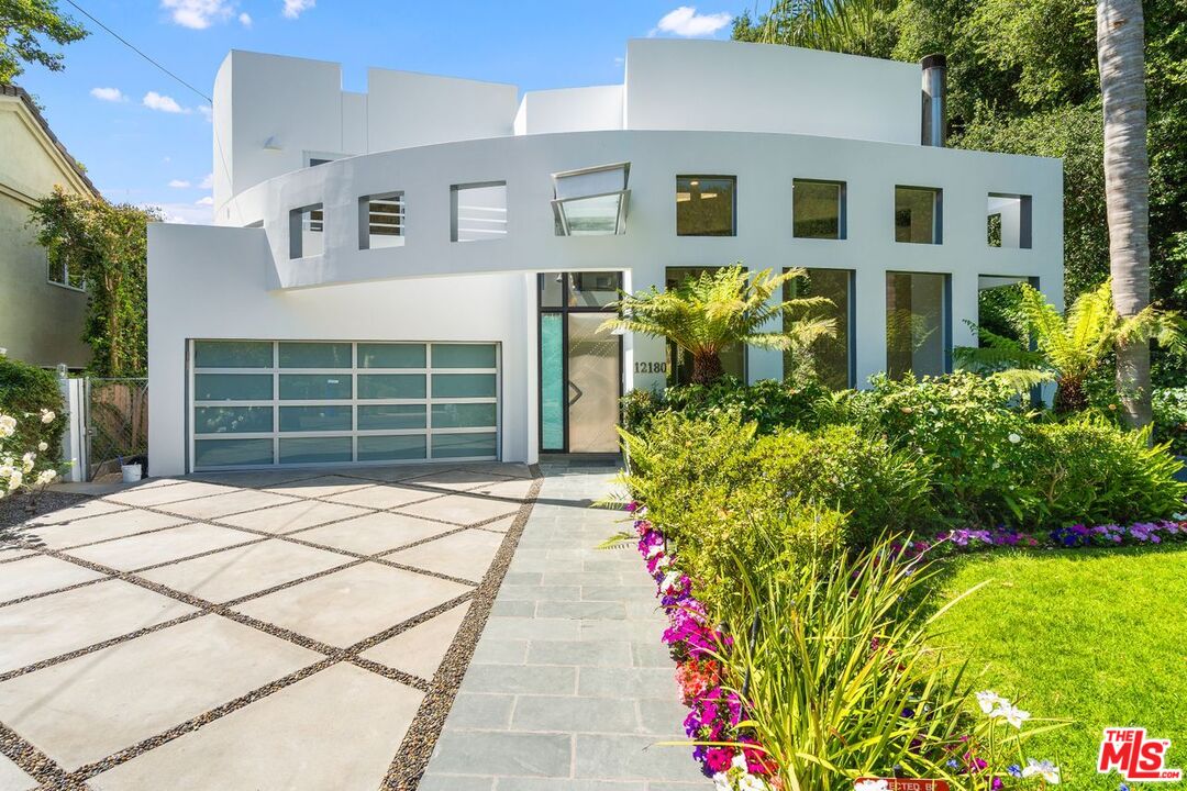 a front view of a house with a garden