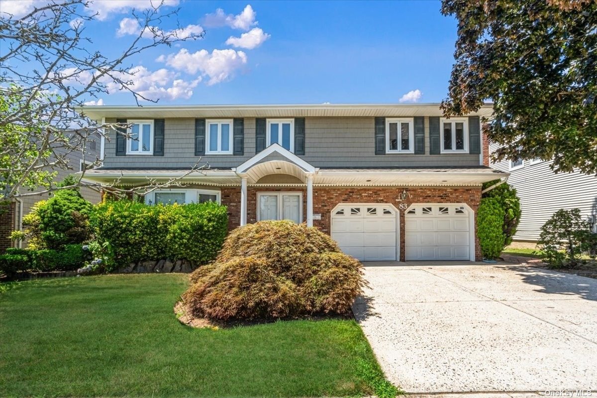 a front view of a house with a garden and yard