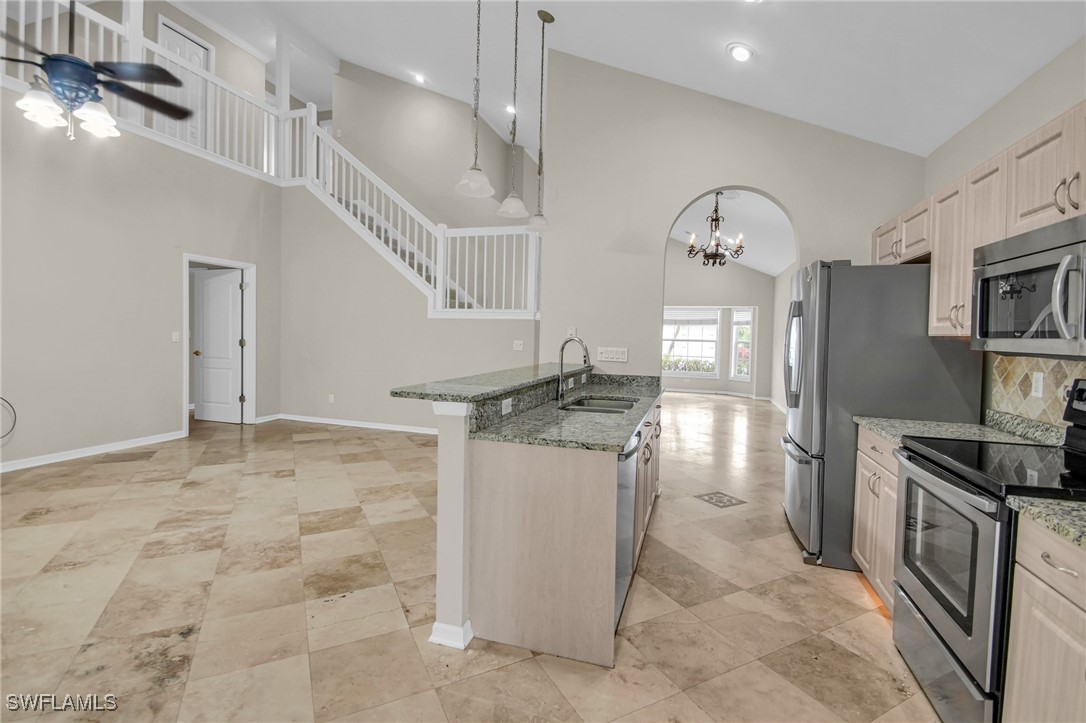 a kitchen with stainless steel appliances granite countertop a stove a sink and a refrigerator