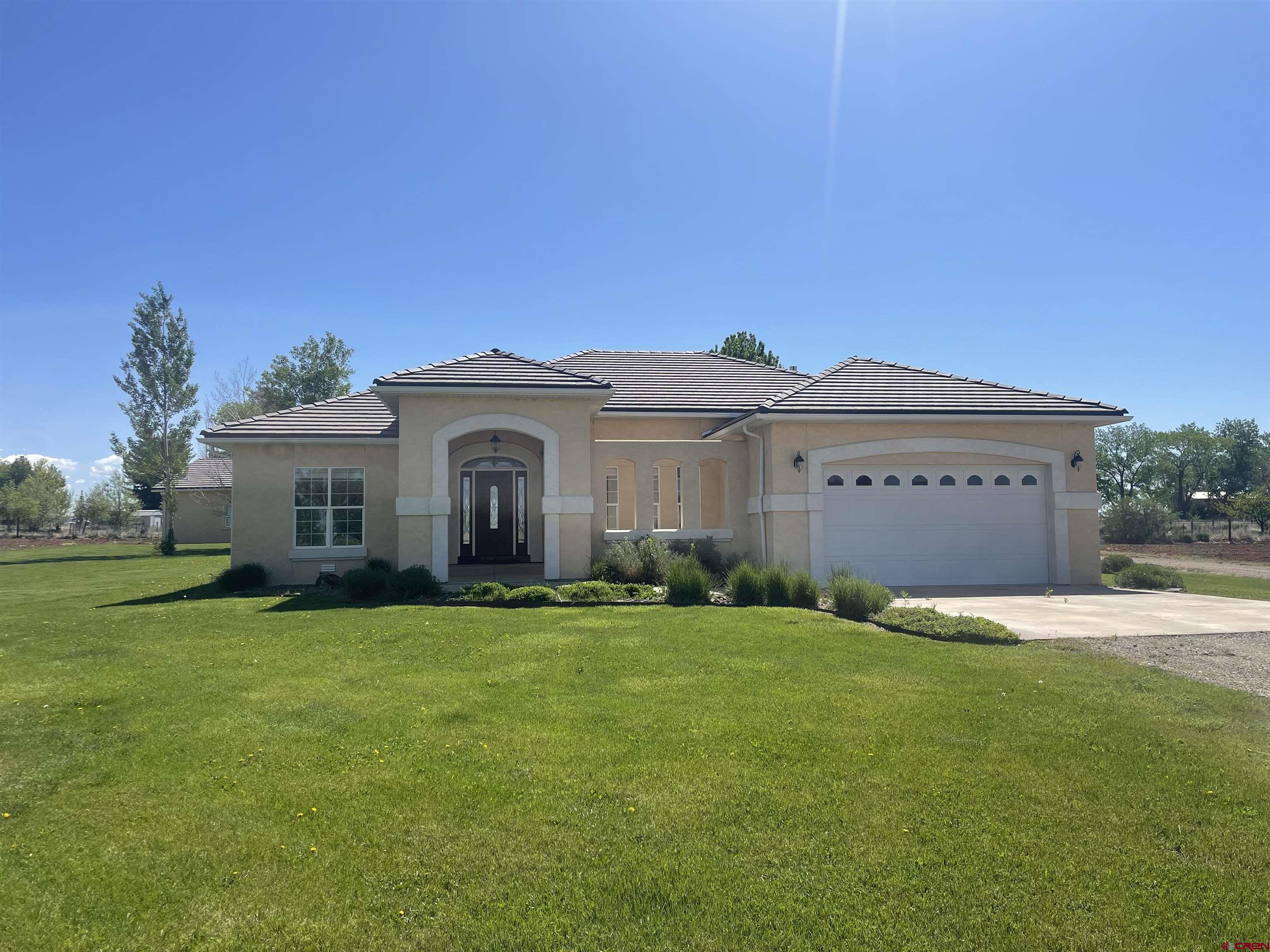 a front view of a house with a garden and yard