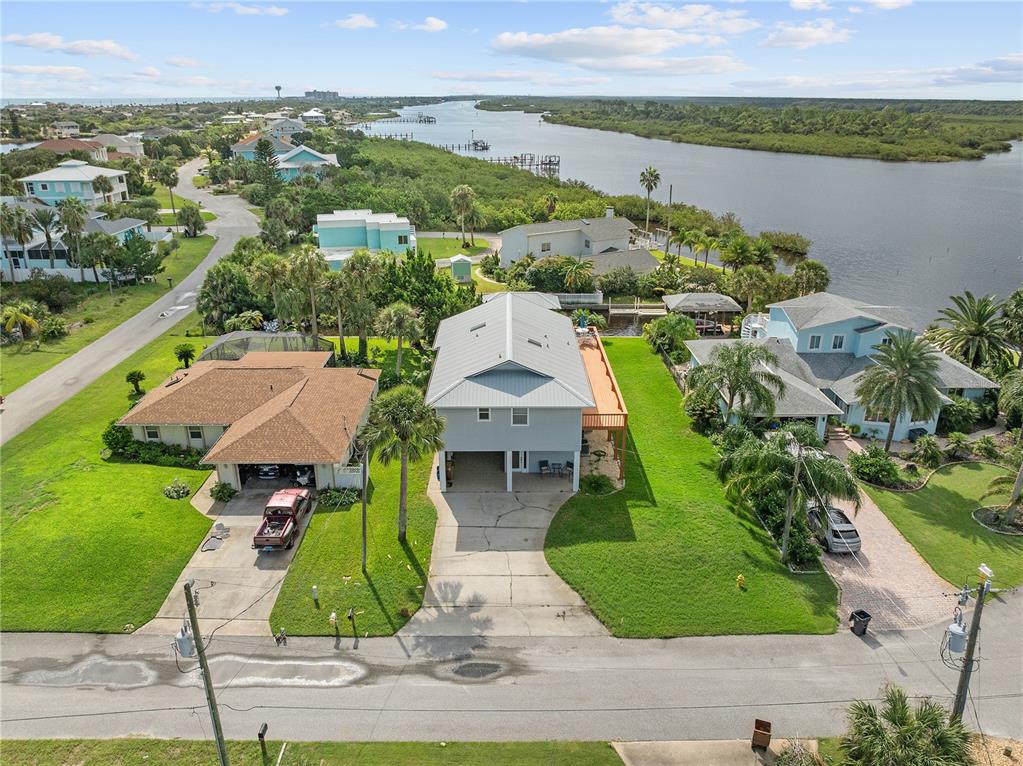 an aerial view of a house with a garden and lake view