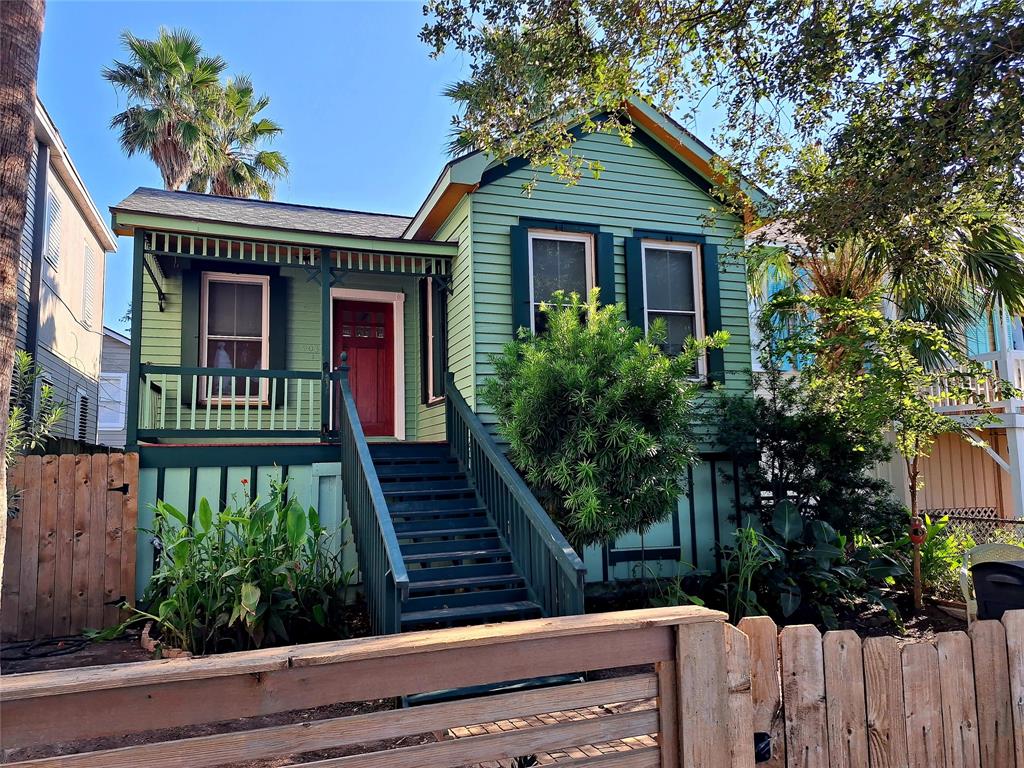 a view of a house with wooden fence and potted plants