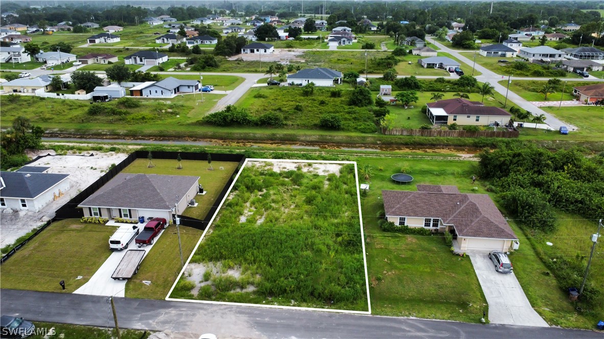 an aerial view of residential houses with outdoor space and parking