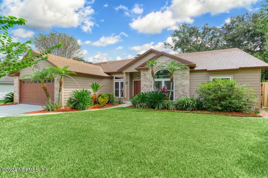 a front view of a house with a yard and trees