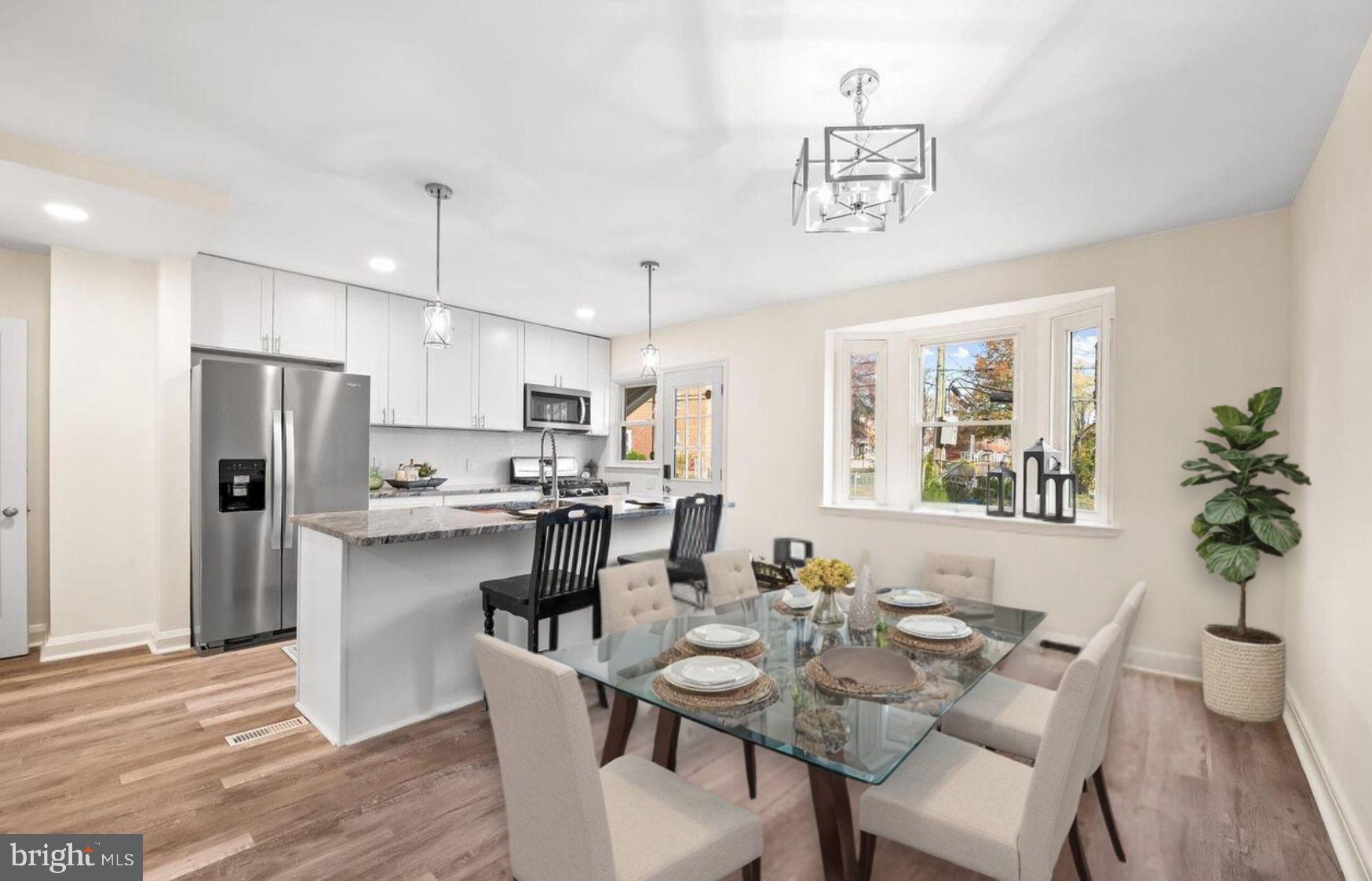 a dining room with stainless steel appliances kitchen island a table and chairs