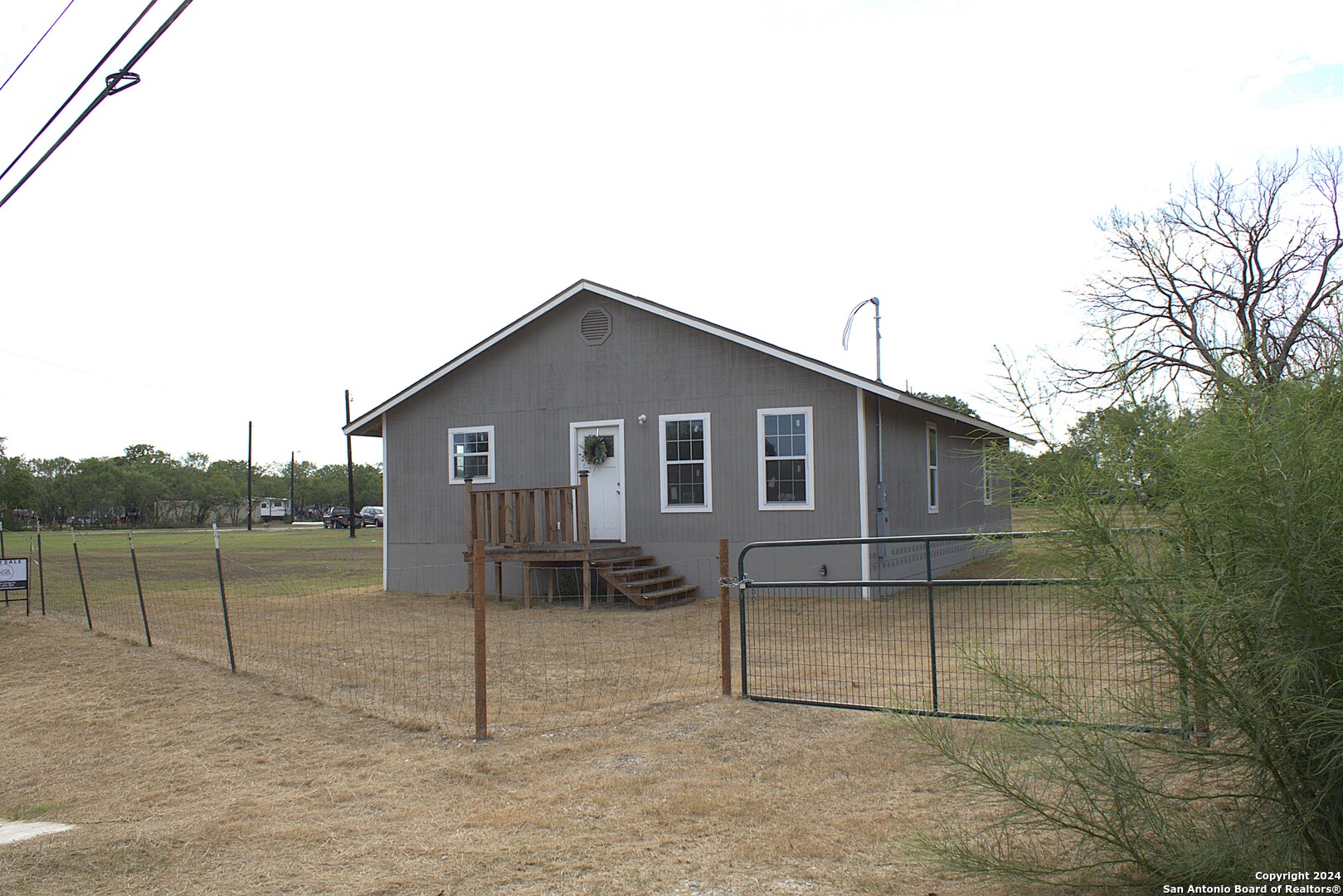 a view of a house with a backyard and a ceiling fan