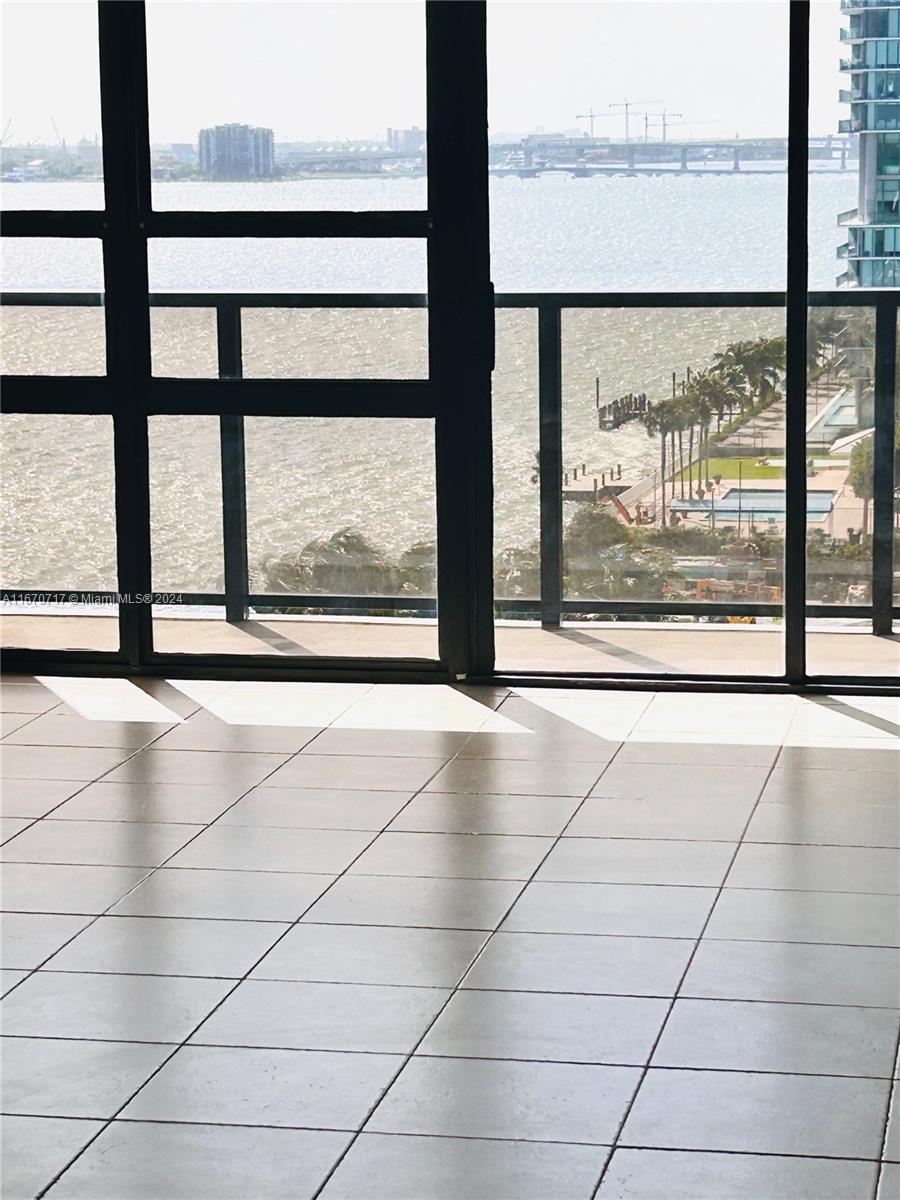 a view of an empty room with a floor to ceiling windows with wooden floor