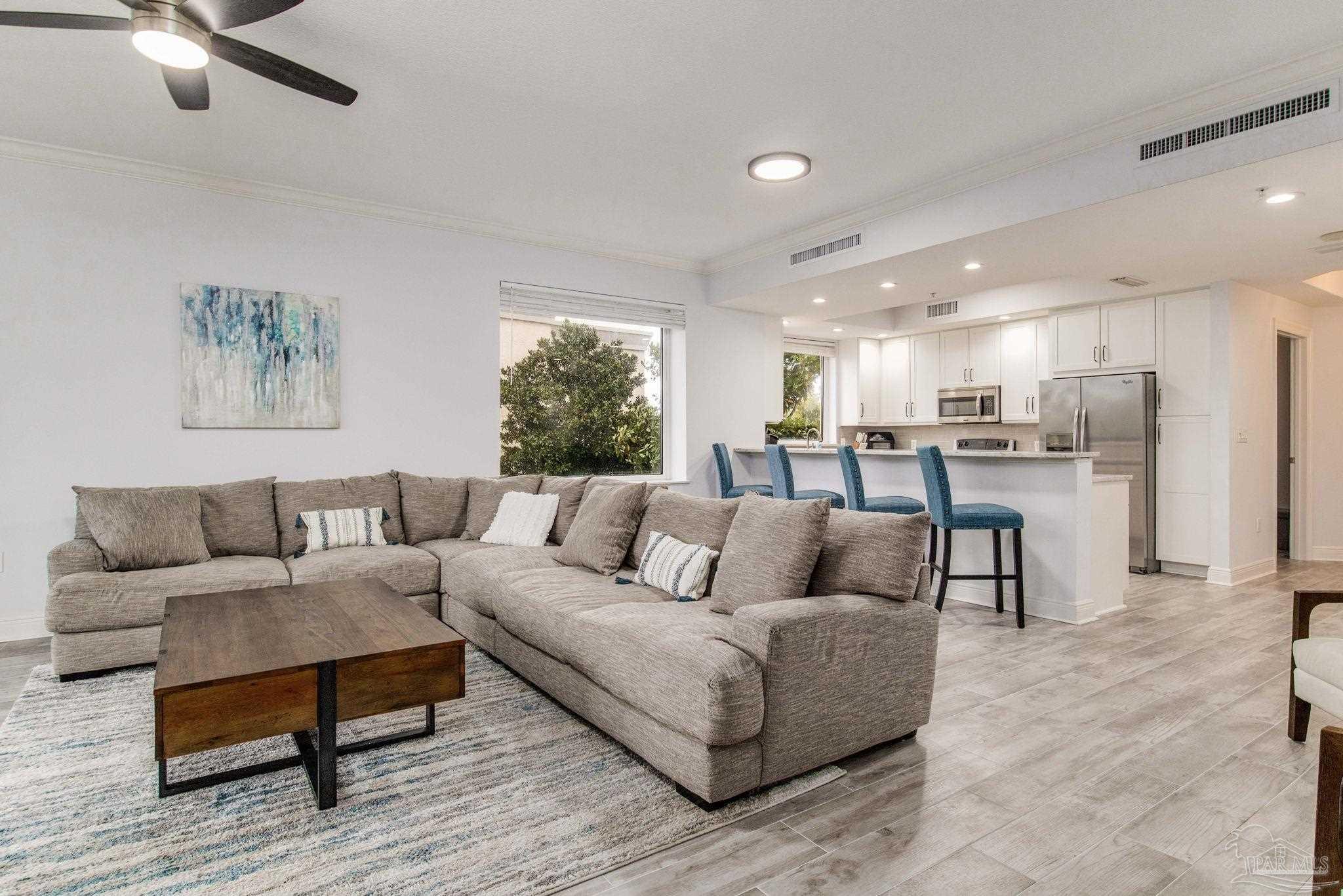 a living room with furniture and kitchen view