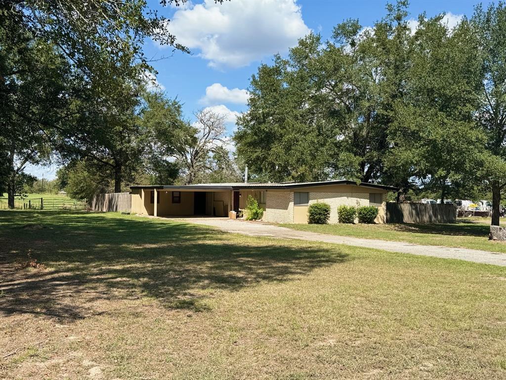 a front view of a house with a yard and trees