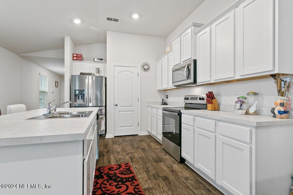 a kitchen with stainless steel appliances kitchen island granite countertop a sink and cabinets