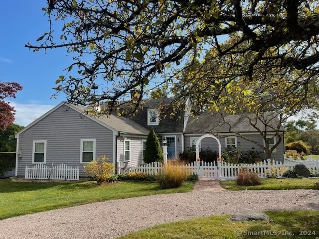 a front view of a house with a garden and tree