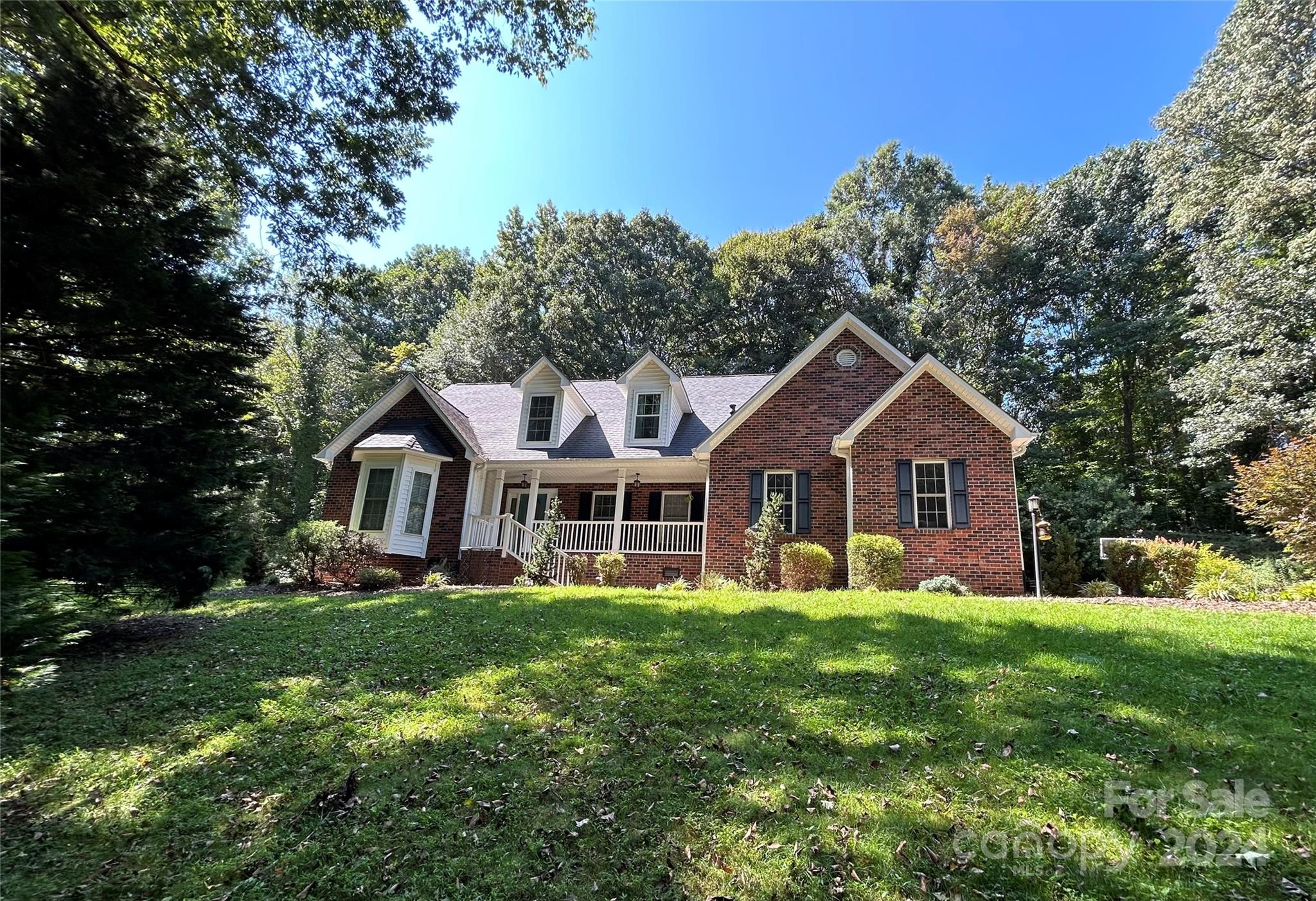 a front view of a house with a yard and trees