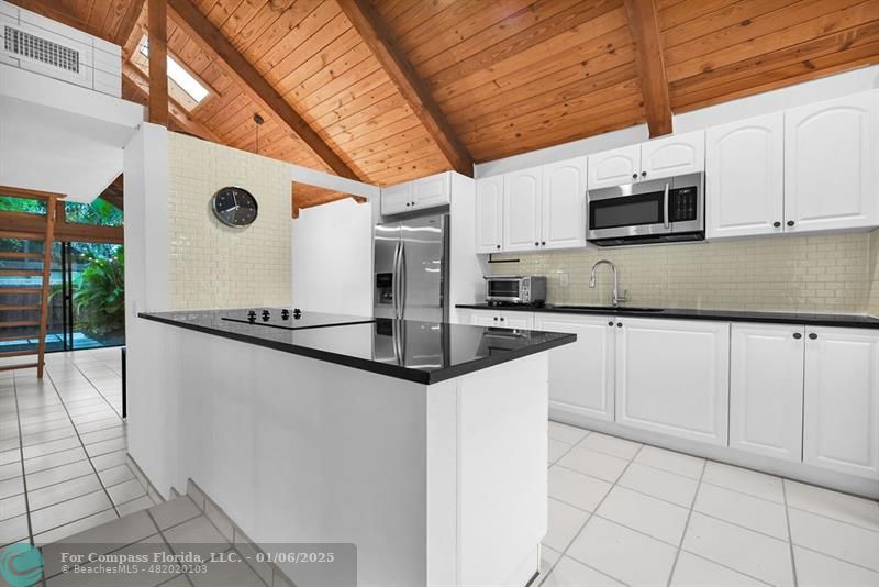 a kitchen with stainless steel appliances granite countertop a sink a microwave and cabinets