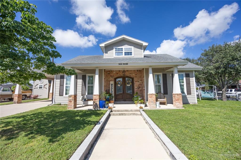 View of front of property featuring a front yard and covered porch