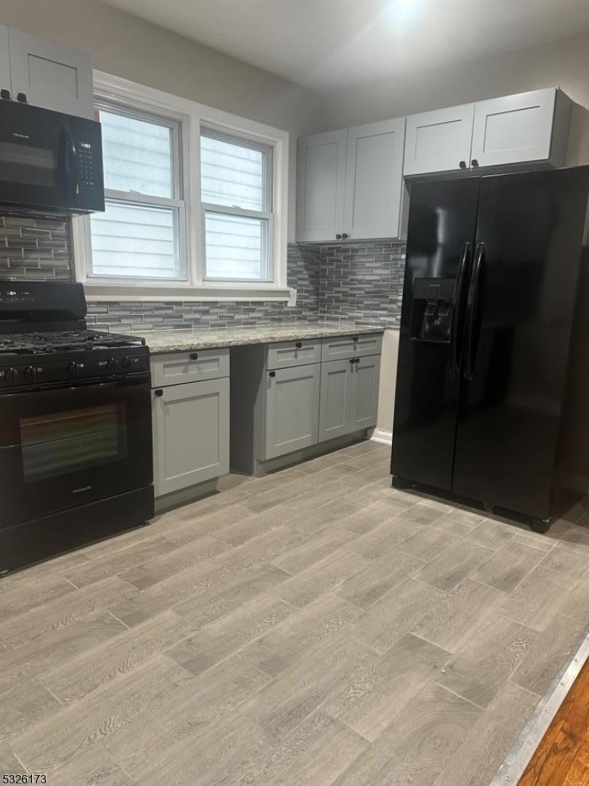 a kitchen with granite countertop a refrigerator stove and microwave