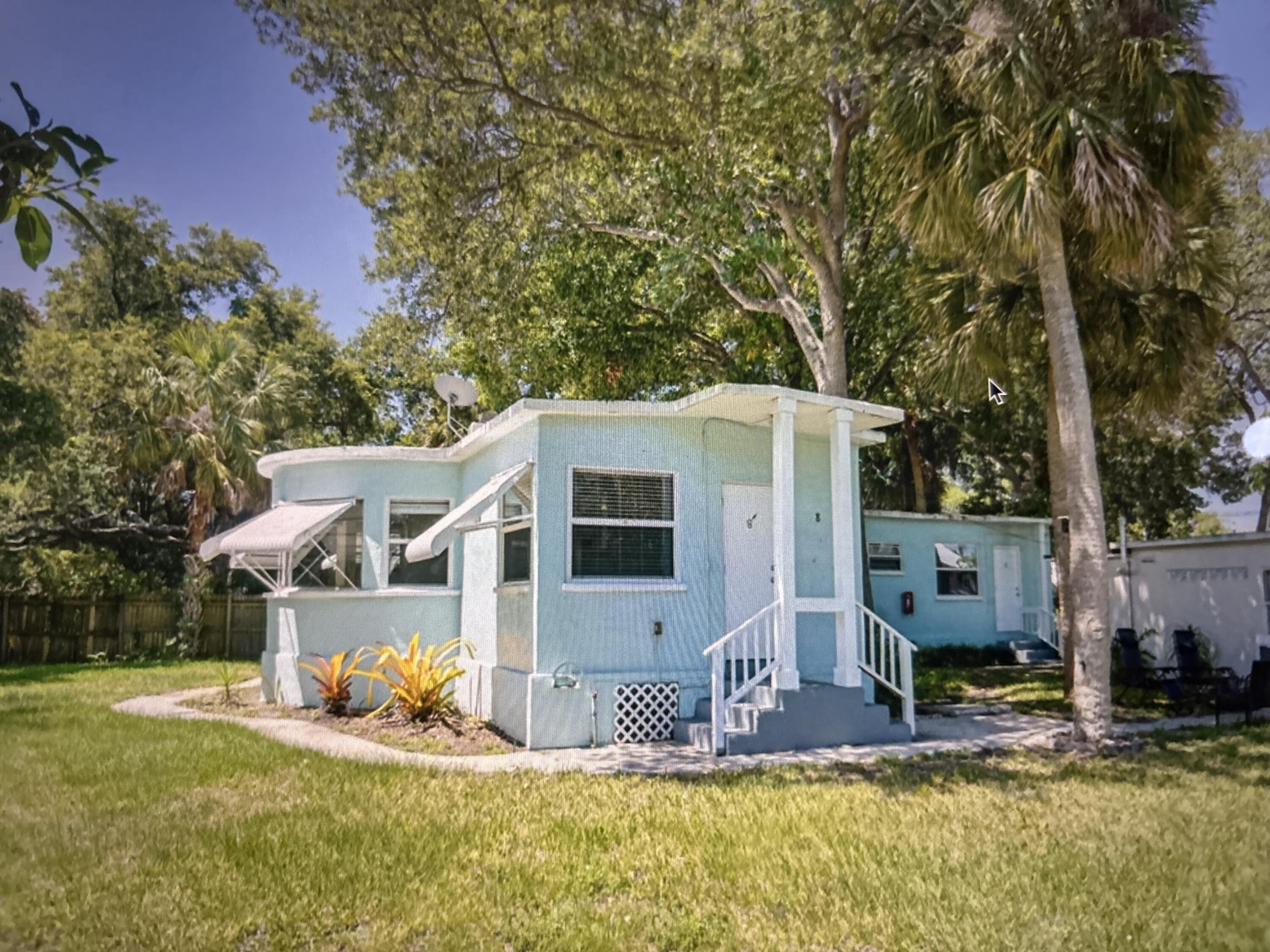 a view of a house with backyard and tree