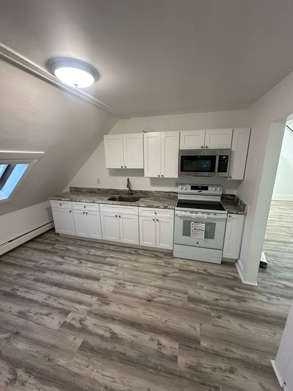 a view of kitchen with microwave stove oven and sink