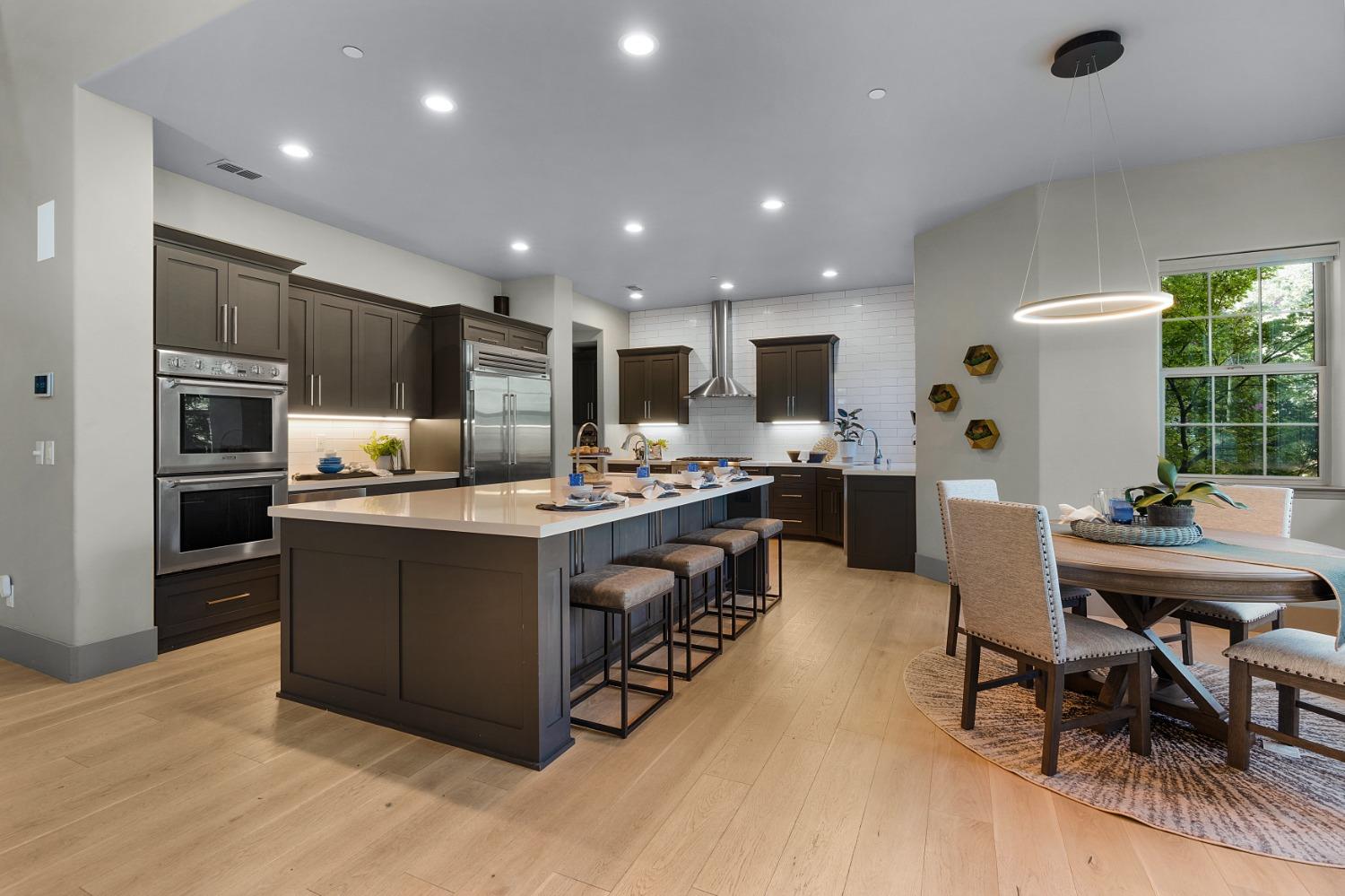 a kitchen with stainless steel appliances kitchen island granite countertop a refrigerator and a stove top oven