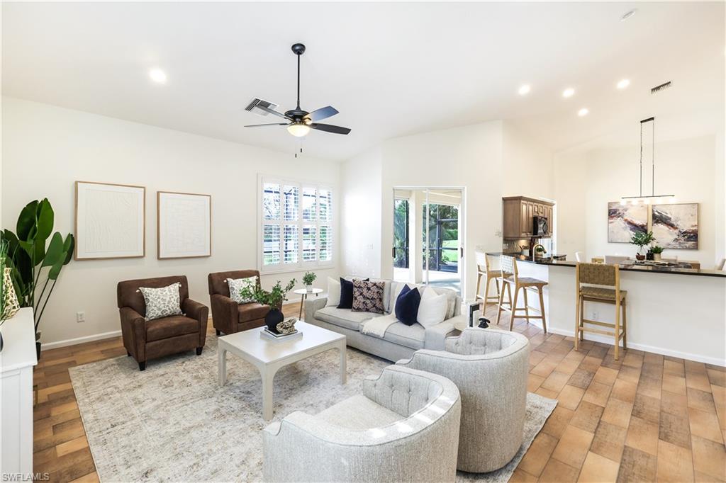 a living room with furniture kitchen view and a chandelier