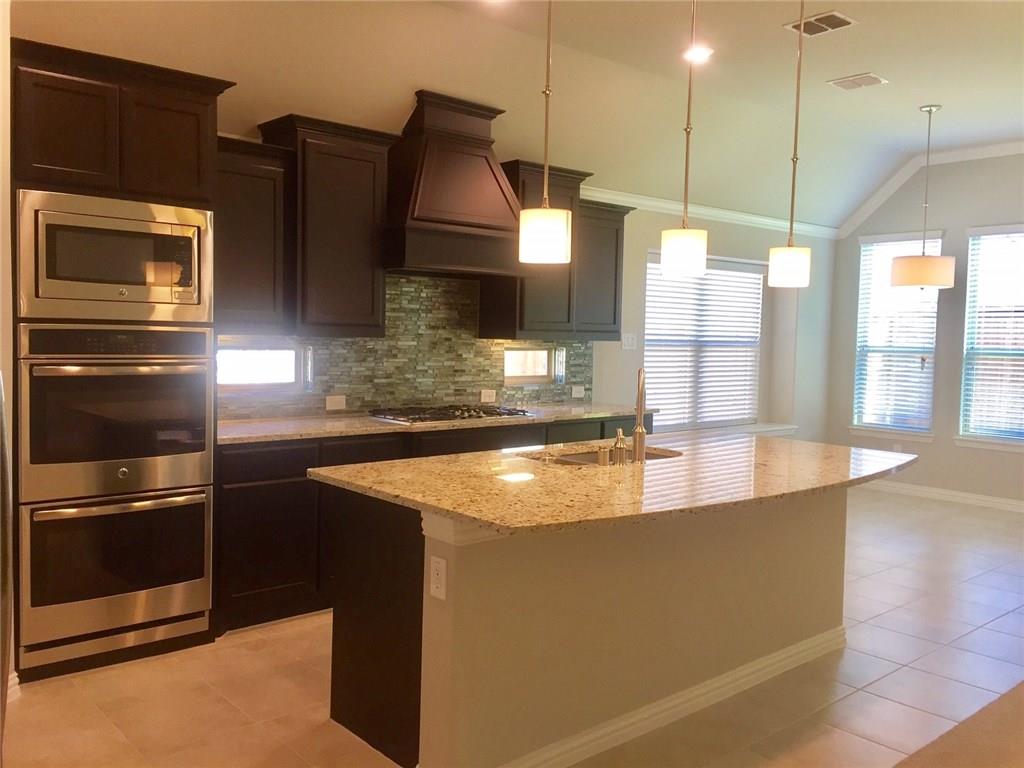 a kitchen with stainless steel appliances granite countertop a sink a oven and a refrigerator