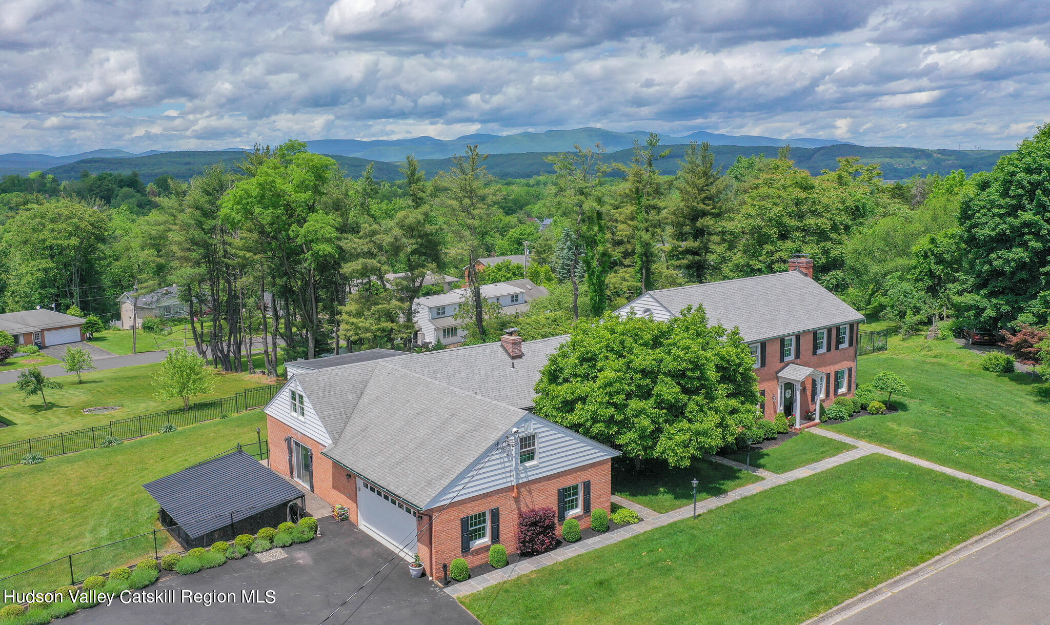 a aerial view of a house next to a big yard and large trees