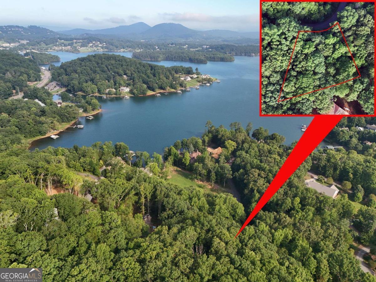 an aerial view of a house with a yard and lake view