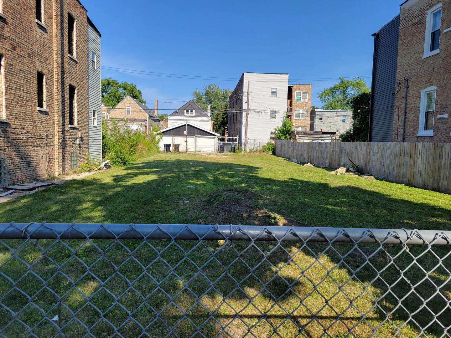 a view of a house with wooden fence and a yard