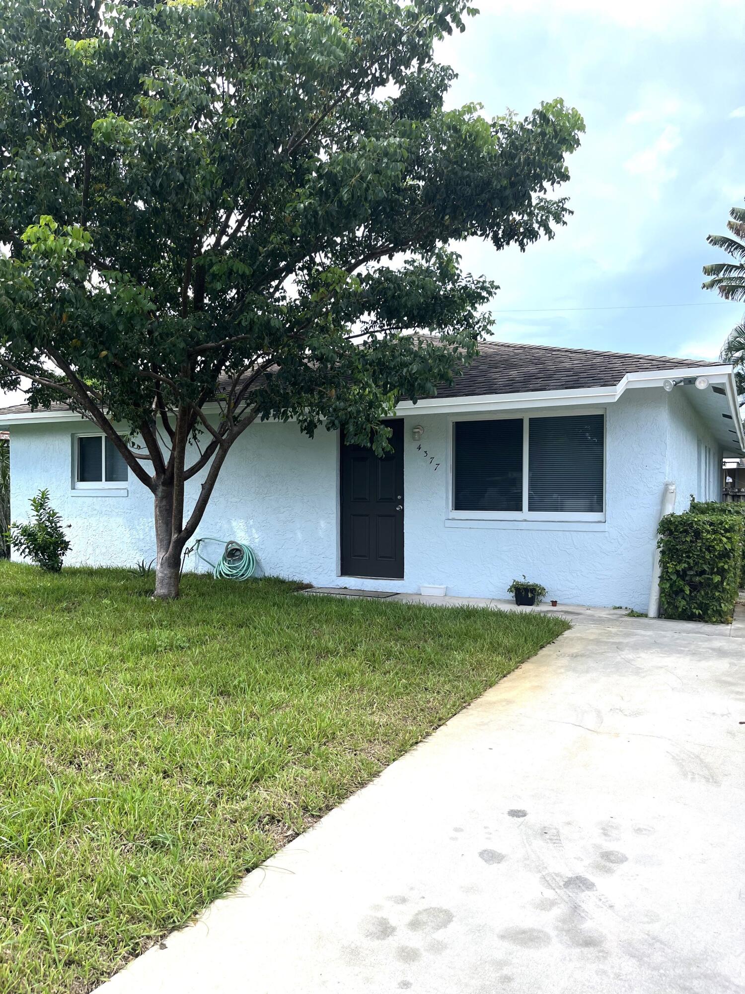 a front view of house with yard and trees