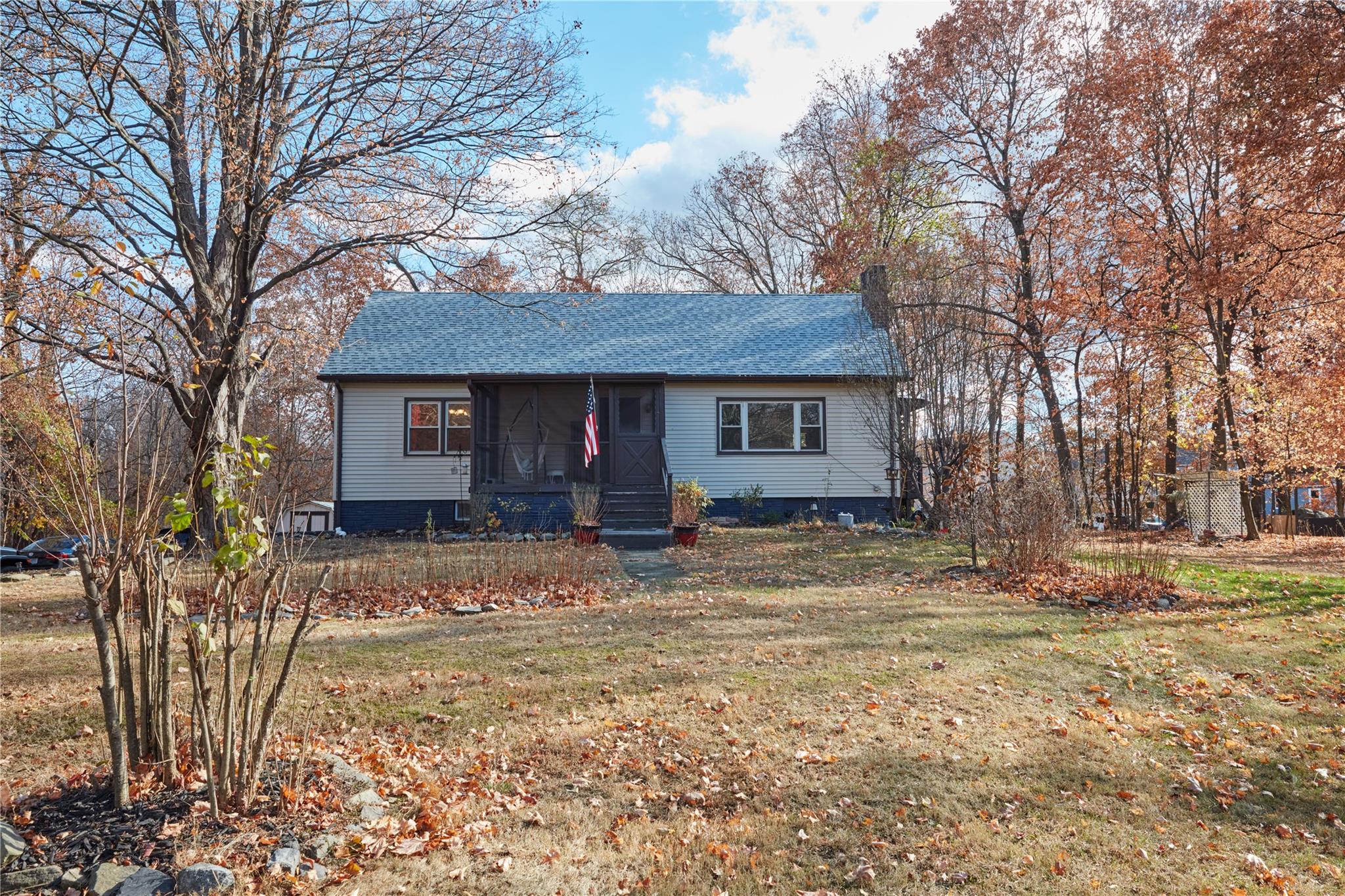 View of front of house with a sunroom and a front lawn