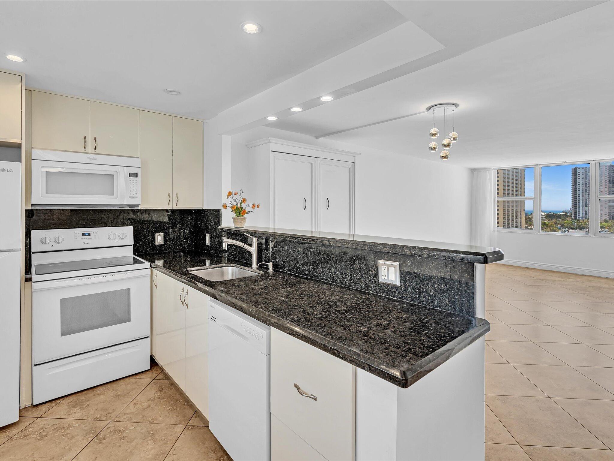 a kitchen with stainless steel appliances granite countertop a sink stove and cabinets