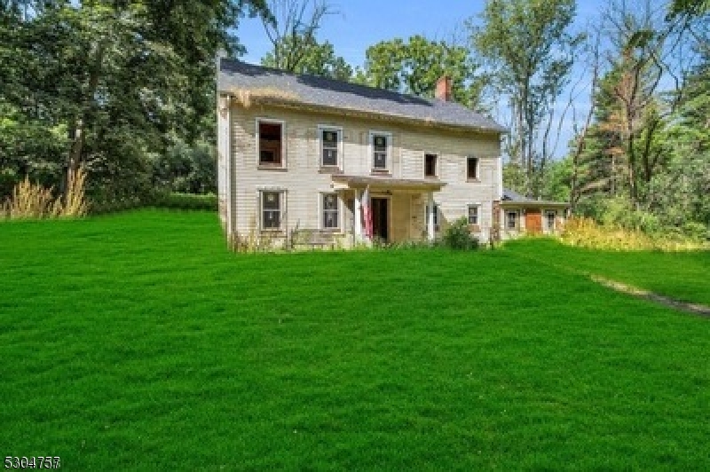 a front view of a house with a garden and trees