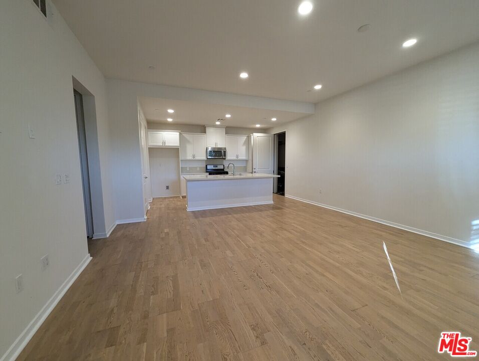 a view of a kitchen with a sink and wooden floor