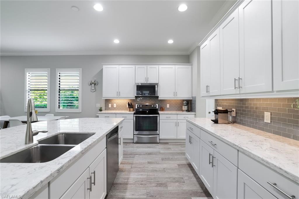 a kitchen with granite countertop white cabinets and white appliances