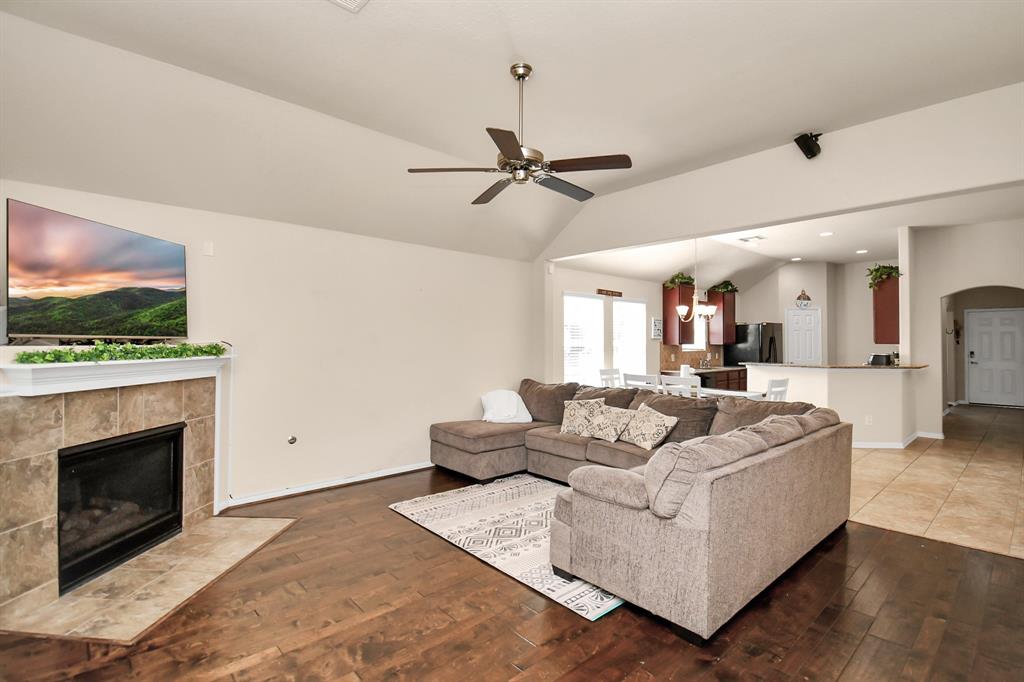 a living room with furniture a flat screen tv and a fireplace