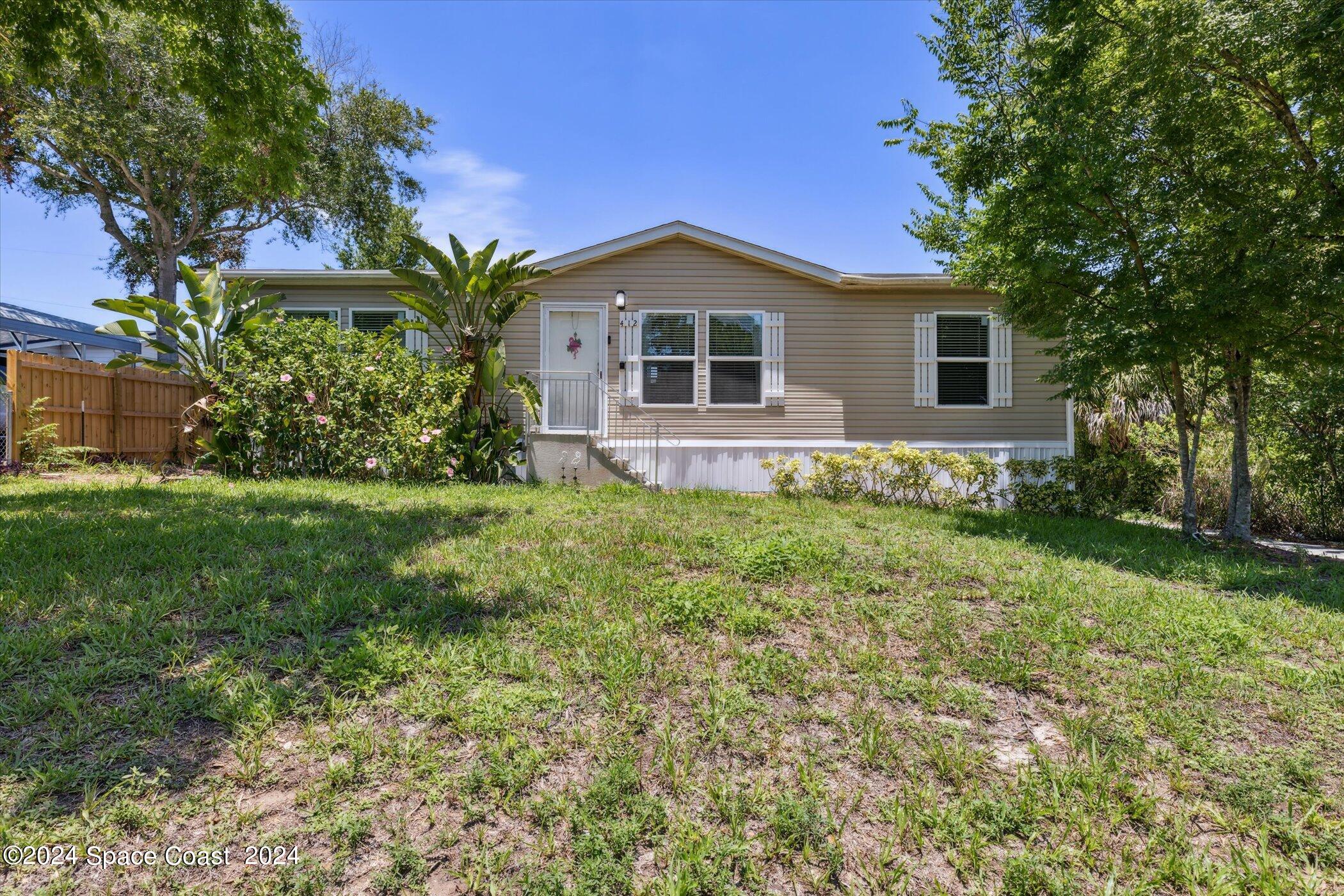 a front view of house with yard and green space