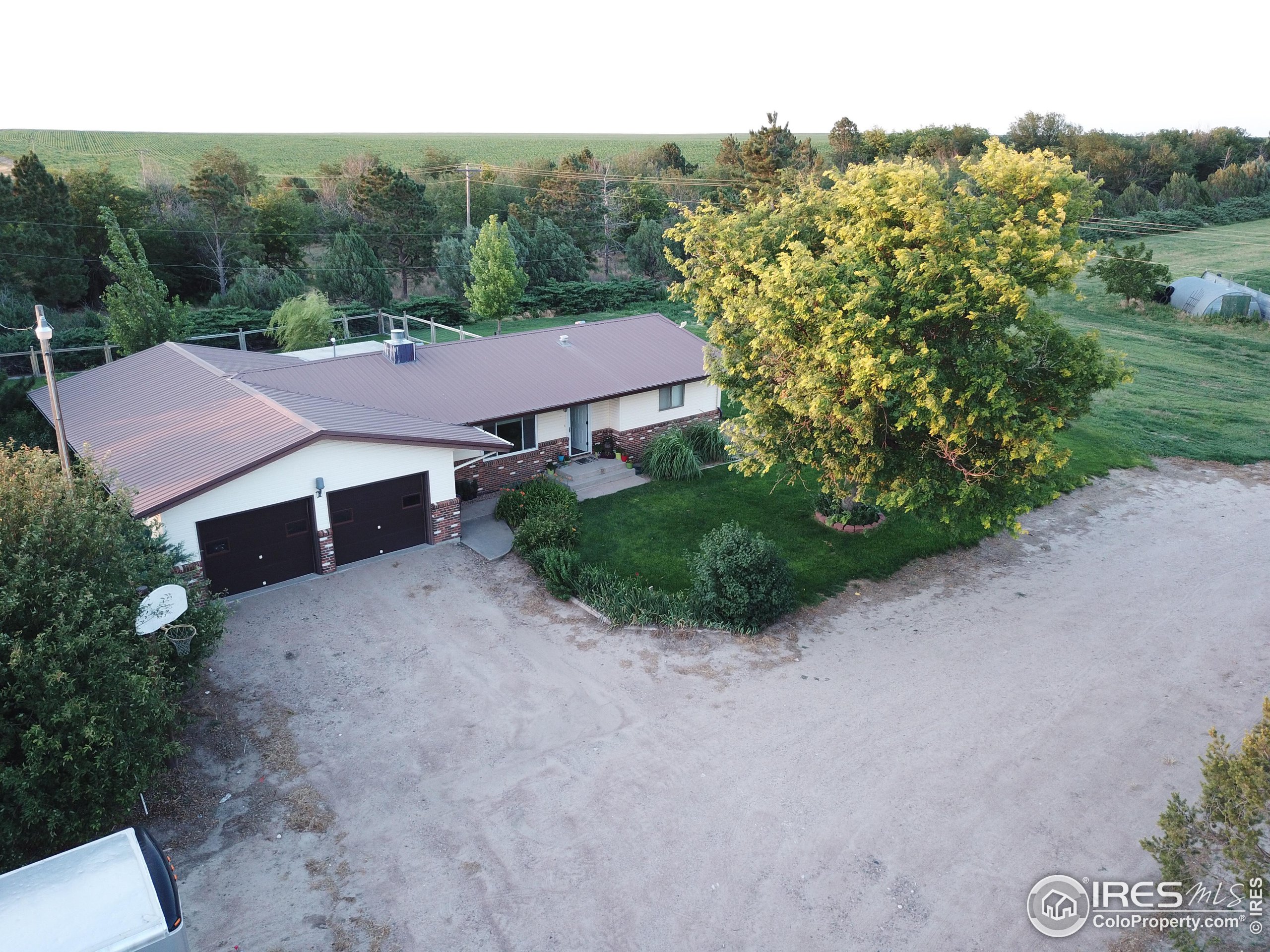 an aerial view of a house with yard and green space