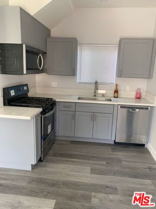 a kitchen with stainless steel appliances granite countertop a sink and a stove top oven