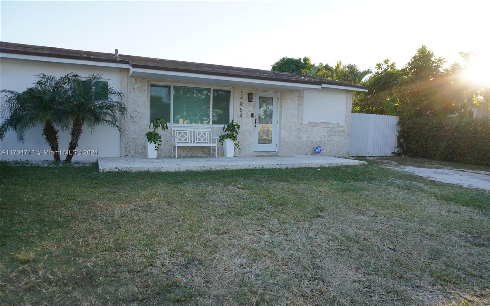 a front view of house with yard and outdoor seating