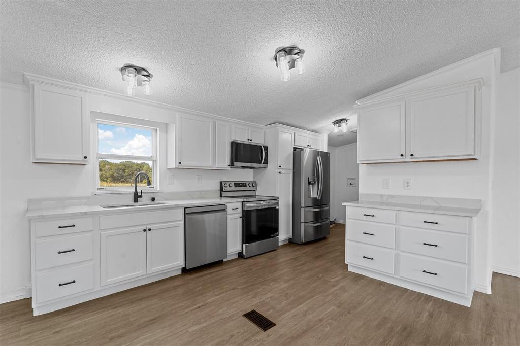 a kitchen with stainless steel appliances a stove a sink and a refrigerator